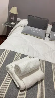 a bed with two towels and a laptop on it at Dpto confortable, super equipado para 4 huéspedes y cerca de todo! in Cordoba