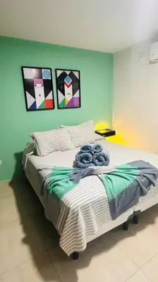 a bedroom with a large bed with paintings on the wall at Apto amoblado temporario in Cordoba