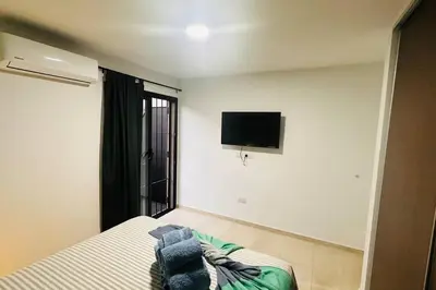 a bedroom with a bed and a tv on the wall at Apto amoblado temporario in Cordoba