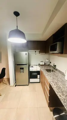 a kitchen with a stainless steel refrigerator and a sink at Apto amoblado temporario in Cordoba