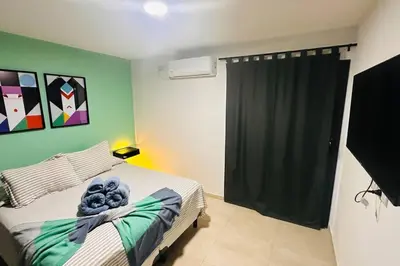 a bedroom with a bed and a green wall at Apto amoblado temporario in Cordoba