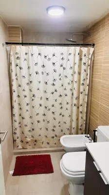 a bathroom with a shower curtain with a toilet at Apto amoblado temporario in Cordoba