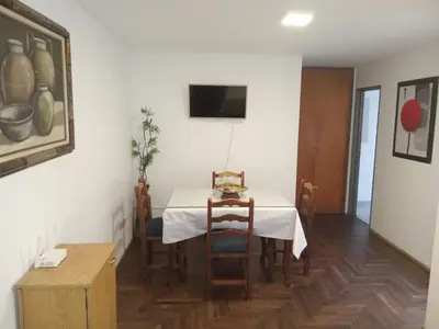 a dining room with a white table and chairs at Departamento en la cañada in Cordoba