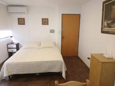 a bedroom with a bed and a brown door at Departamento en la cañada in Cordoba
