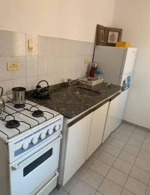a kitchen with a stove and a white refrigerator at Departamento en la cañada in Cordoba