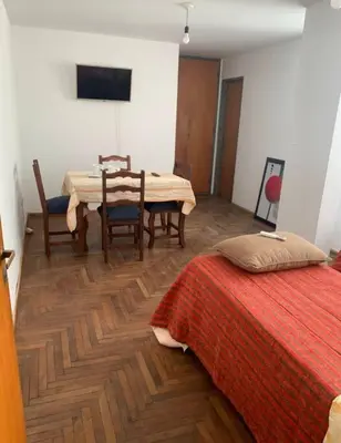 a bedroom with a table and a bed and a table and chairs at Departamento en la cañada in Cordoba