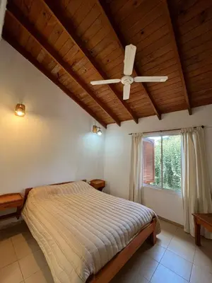 a bedroom with a bed and a ceiling fan at El refugio - Cuatro Horizontes in Villa General Belgrano
