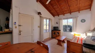 a kitchen with a table and a dining room at El refugio - Cuatro Horizontes in Villa General Belgrano