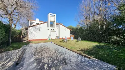 a white house with a sign on the front of it at El refugio - Cuatro Horizontes in Villa General Belgrano