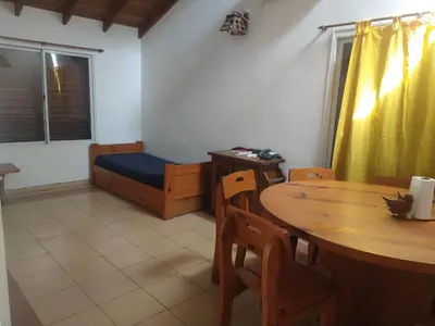 a room with a table and a bed and a table and chairs at El refugio - Cuatro Horizontes in Villa General Belgrano