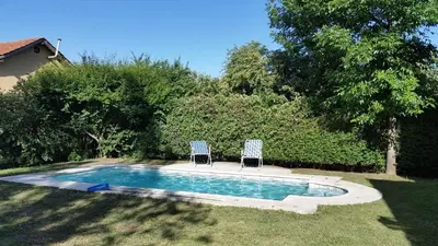 two chairs sitting next to a swimming pool at El refugio - Cuatro Horizontes in Villa General Belgrano