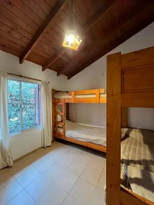 a bedroom with two bunk beds and a window at El refugio - Cuatro Horizontes in Villa General Belgrano