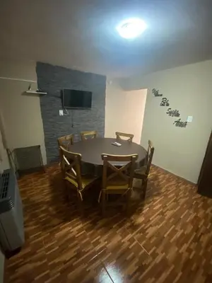 a room with a table and chairs and a television at La casita in Villa Carlos Paz