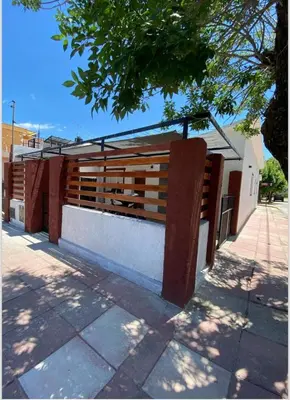 a wooden bench on the side of a building at La casita in Villa Carlos Paz