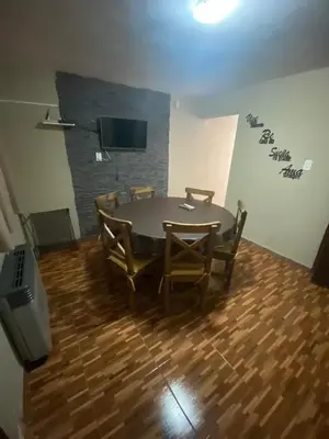 a dining room with a table and chairs and a television at La casita in Villa Carlos Paz