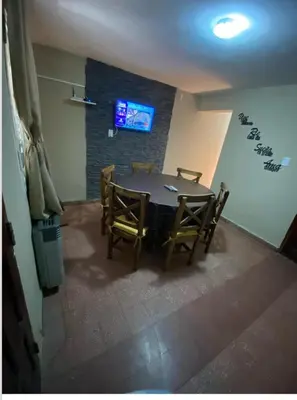a dining room with a table and chairs and a tv at La casita in Villa Carlos Paz