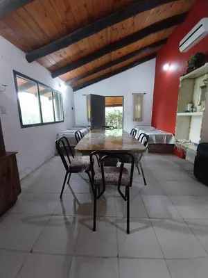 a dining room with a wooden table and chairs at Pintacho Cabañas, casa in Villa Anizacate