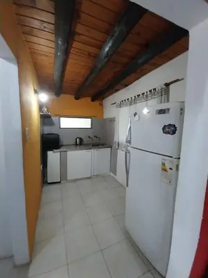 a kitchen with a white refrigerator in a room at Pintacho Cabañas, casa in Villa Anizacate