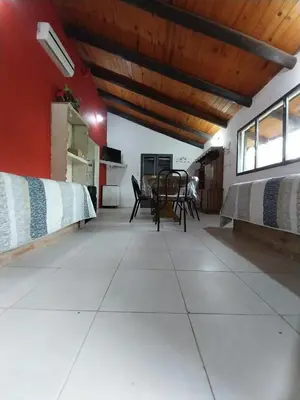 a living room with two beds and a table at Pintacho Cabañas, casa in Villa Anizacate