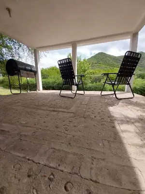two black chairs sitting on a porch with a view at Pintacho Cabañas, casa in Villa Anizacate