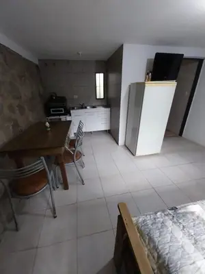 a room with a kitchen with a table and a refrigerator at Pintacho Cabañas, casa in Villa Anizacate