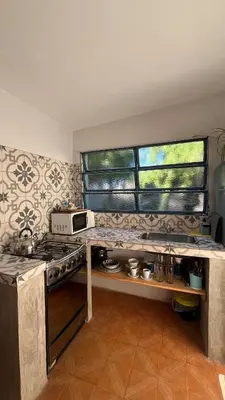 a kitchen with a stove and a microwave at Casa Milos para dos personas frente al rio in Santa Rosa de Calamuchita