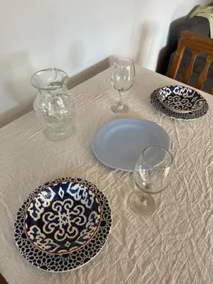 a table with plates and glasses on a table at Casa Milos para dos personas frente al rio in Santa Rosa de Calamuchita