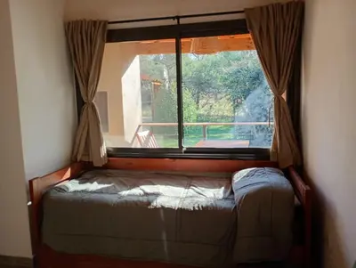 a window in a room with a bed in front of it at Las Moras in Santa Rosa de Calamuchita