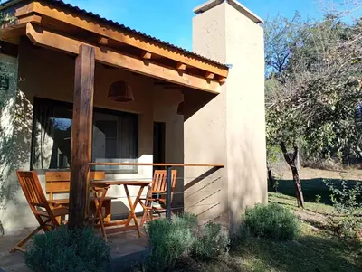 a porch of a house with a table and chairs at Las Moras in Santa Rosa de Calamuchita