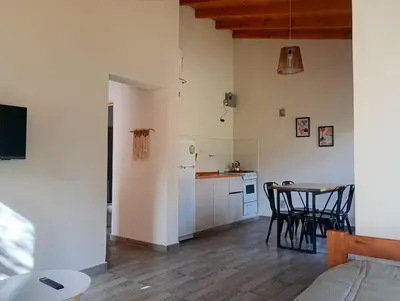 a kitchen and dining room with a table and chairs at Las Moras in Santa Rosa de Calamuchita