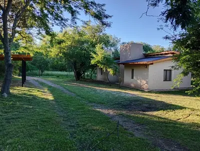 a house in the middle of a field with a road at Las Moras in Santa Rosa de Calamuchita