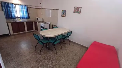 a kitchen with a table and chairs in a room at Los Luises - Departamentos Céntricos in Mina Clavero