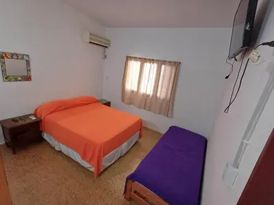 a small bedroom with a bed and a window at Los Luises - Departamentos Céntricos in Mina Clavero