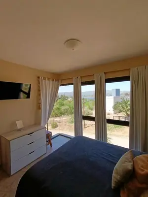 a bedroom with a bed and a large window at Complejo Refugio Playa Perelli in Villa Carlos Paz