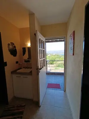 a hallway leading to a kitchen with a door to a balcony at Complejo Refugio Playa Perelli in Villa Carlos Paz