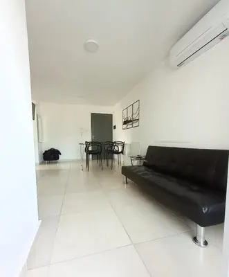 a living room with a black couch and a table at TEMPO GÜEMES Departamento en Güemes, casi Nueva Córdoba in Cordoba