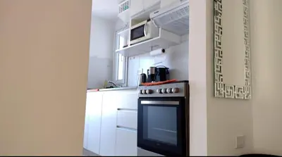 a kitchen with a black stove and white cabinets at TEMPO GÜEMES Departamento en Güemes, casi Nueva Córdoba in Cordoba