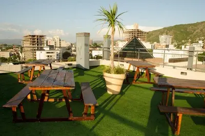 a group of picnic tables on the roof of a building at Departamento, Terraza con PISCINA, SUM y PARRILLAS a 2 cuadras de PEATONAL in Villa Carlos Paz