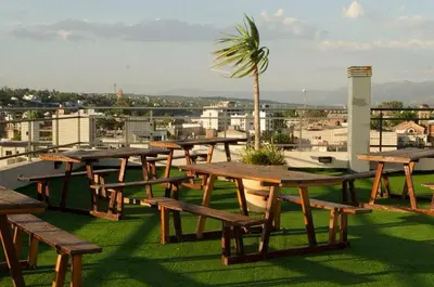 a group of picnic tables on the roof of a building at Departamento, Terraza con PISCINA, SUM y PARRILLAS a 2 cuadras de PEATONAL in Villa Carlos Paz