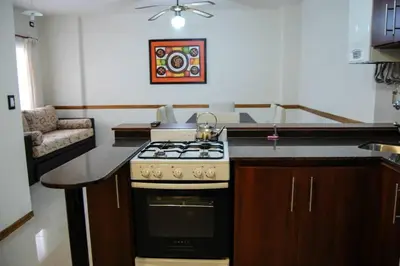 a kitchen with a stove top oven in a kitchen at Departamento, Terraza con PISCINA, SUM y PARRILLAS a 2 cuadras de PEATONAL in Villa Carlos Paz