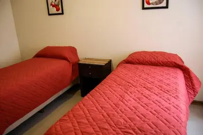 two beds sitting next to each other in a room at Departamento, Terraza con PISCINA, SUM y PARRILLAS a 2 cuadras de PEATONAL in Villa Carlos Paz