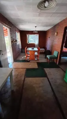 a living room with a table and chairs at Al Pie Del Cerro Champaqui in Los Hornillos