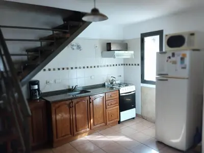 a kitchen with a sink and a refrigerator at AMALGAMA CABAÑAS in Merlo