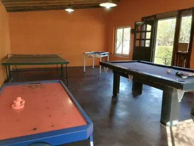 a room with two ping pong tables in it at AMALGAMA CABAÑAS in Merlo