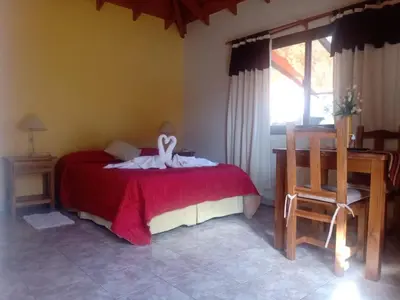 a bedroom with a bed with a white bird on it at AMALGAMA CABAÑAS in Merlo