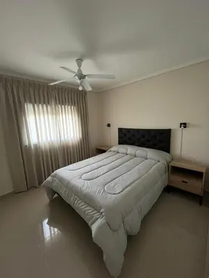 a bedroom with a large bed with a ceiling fan at Departamento Terraforte 2 in Cordoba