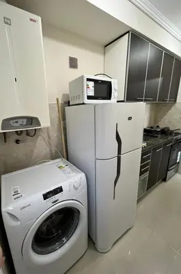 a kitchen with a washing machine and a microwave at Departamento Terraforte 2 in Cordoba