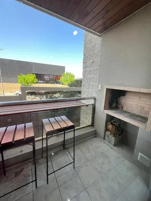 a balcony with two chairs and a fireplace at Departamento Terraforte 2 in Cordoba