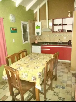 a kitchen with a table and chairs and a kitchen with green walls at Los Laureles de Sorso in Villa Ciudad Parque