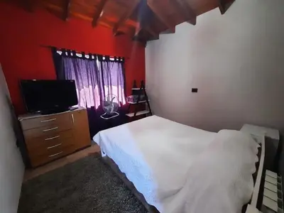a bedroom with a bed and a flat screen tv at Lodelore in Merlo